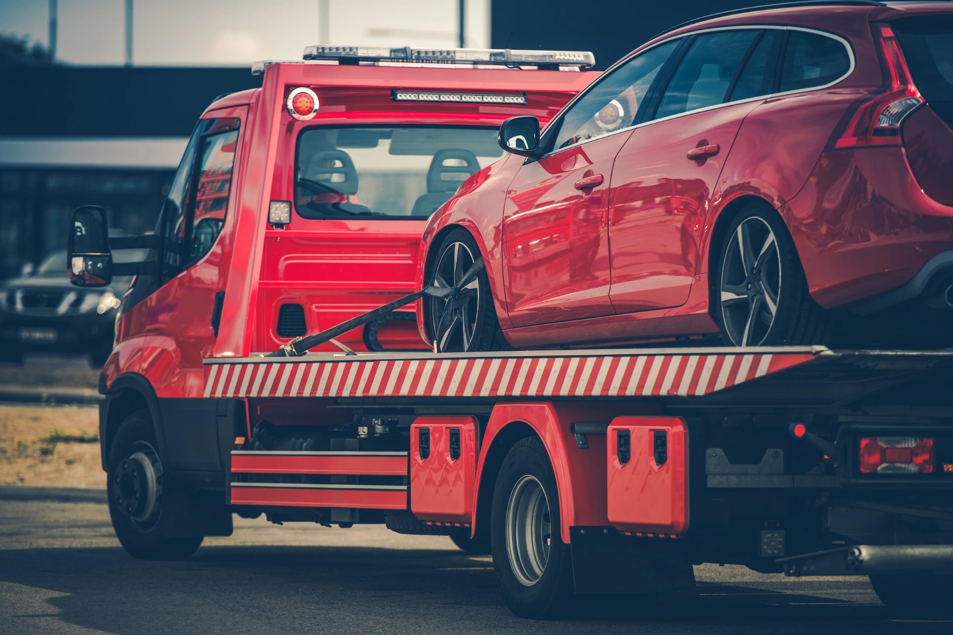 Coastal car shipping – vehicle being loaded onto an auto transport carrier near a beach, protected from saltwater damage