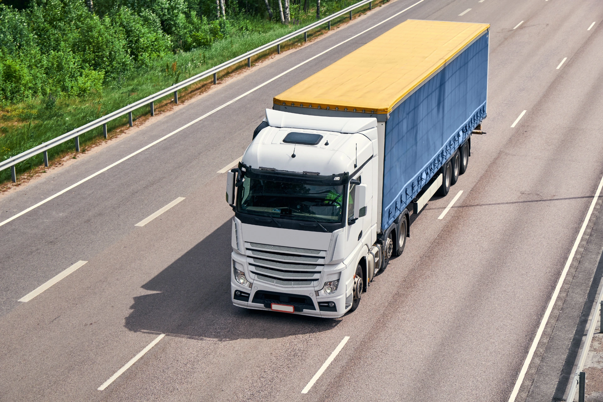 A large semi-truck on a highway, representing the land transport portion of Hawaii car shipping.